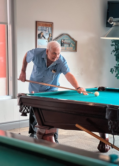 Partie de billard entre aînés dans l’espace de loisirs